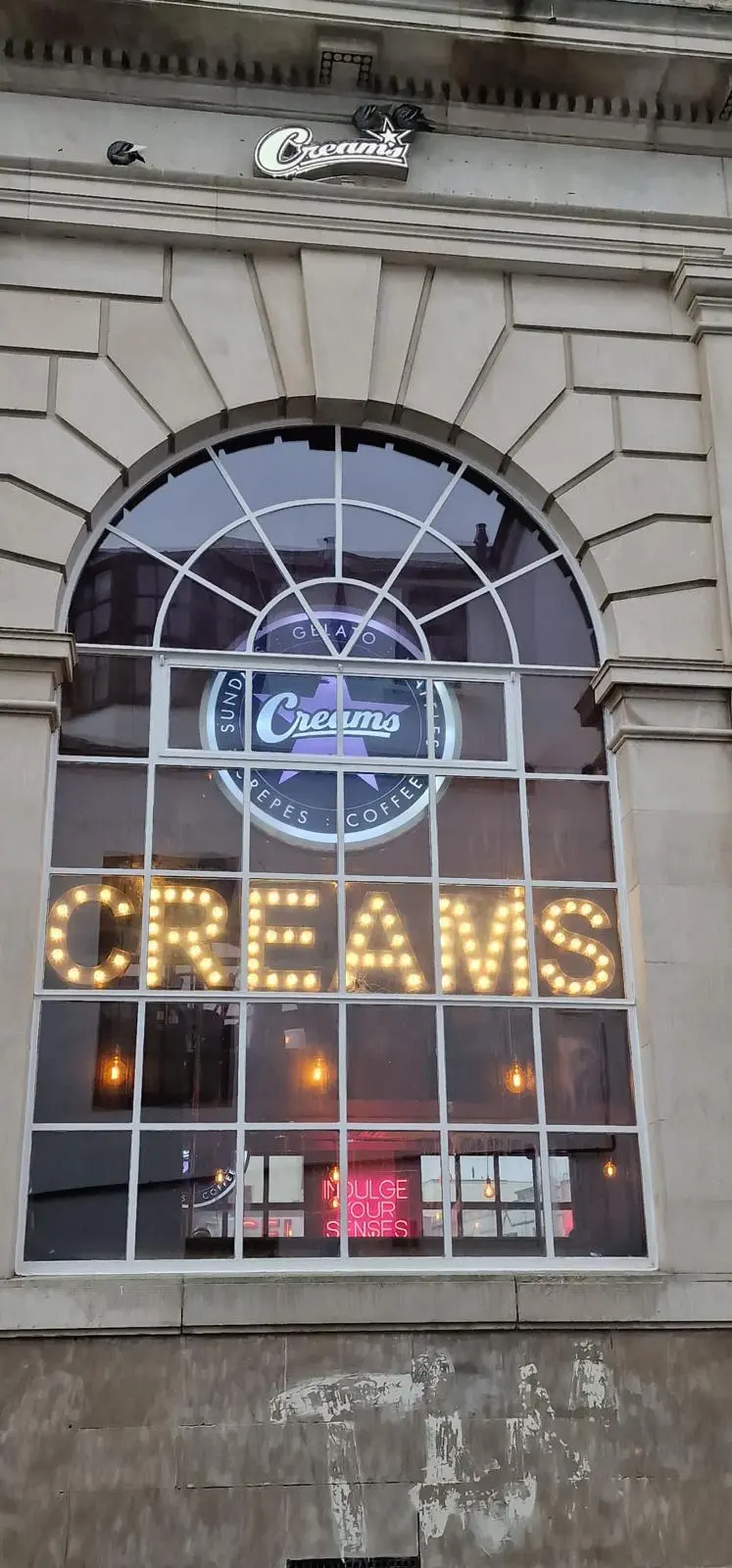 LED retail signage for Creams Cafe enhancing night-time visibility Illuminated signage for Creams Cafe featuring warm LED lights for high visibility