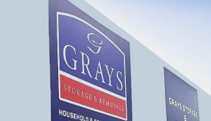 A clean and professional flat panel signage solution with applied graphics, ideal for businesses looking for cost-effective branding. Blue flat panel signage for Grays Storage & Removals.