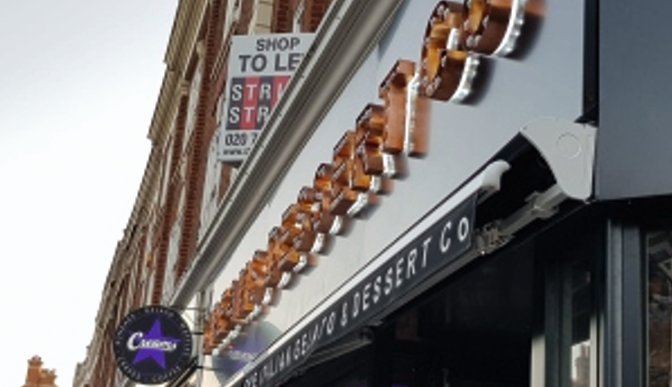 Vintage-style signage featuring LED light bulbs for a warm and nostalgic illuminated display, perfect for storefront branding. raditional fairground-style light bulb signage for a business exterior.