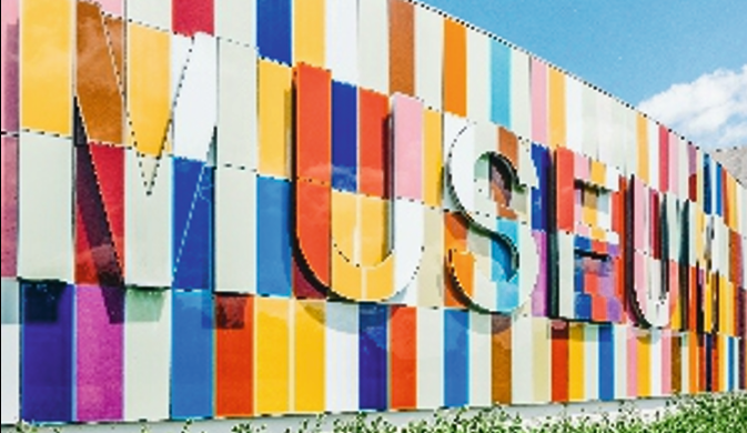 Flat cut lettering signage installed on a vibrant, multi-coloured facade, providing a modern and professional finish for business branding. Colourful flat cut letter signage on a modern building exterior.