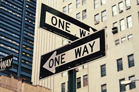 Black and white One Way street signs in a city