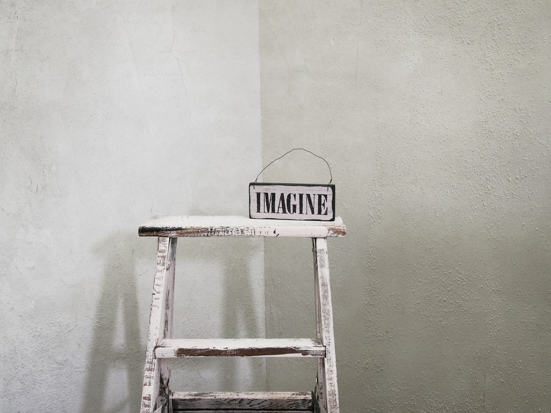 Rustic wooden ladder with 'IMAGINE' sign