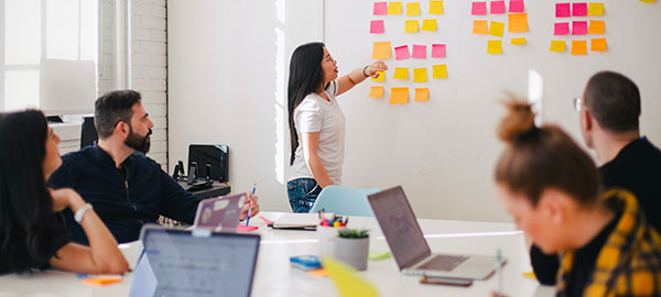 Team collaborating on signage design with sticky notes on a whiteboard